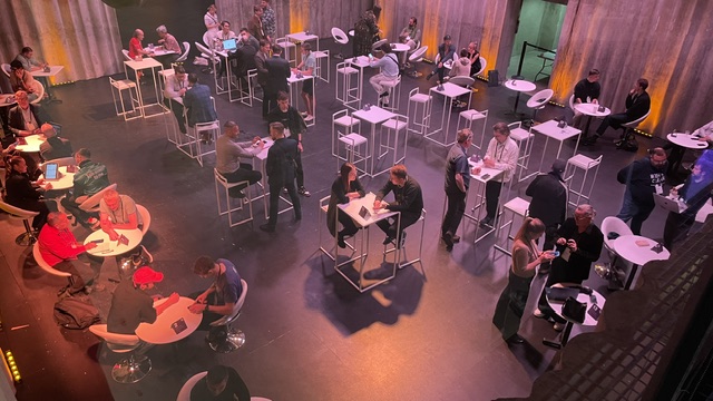 The meeting-point floor at Latitude59: numbered tables, booked through the event app.